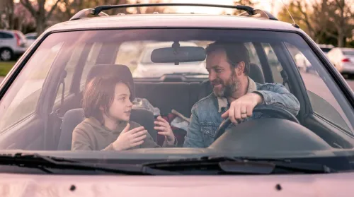 Father and pre-teen talking honestly in a parked car, an everyday moment of family communication